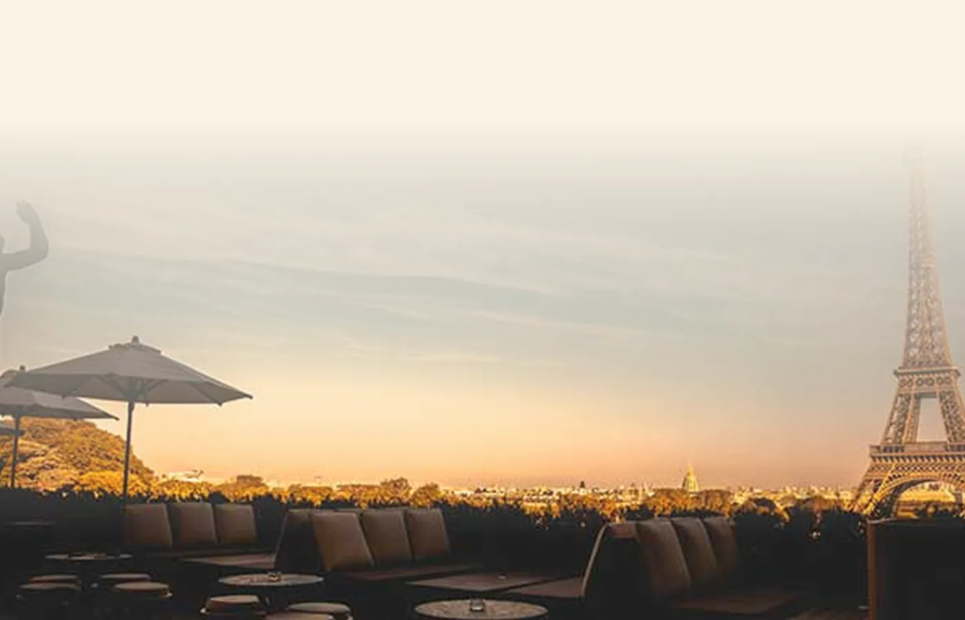Vista de um terraço em Paris ao entardecer, com a Torre Eiffel ao fundo